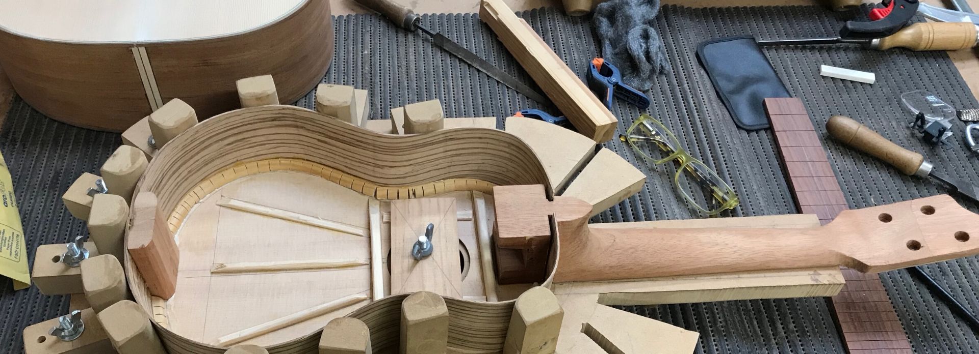 Una guitarra en construcción en el banco del taller